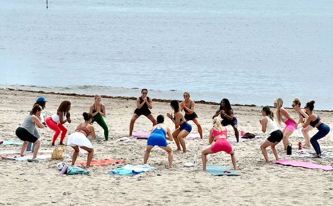 A large group training together on the beach in Miami, led by Amanda Ferreira